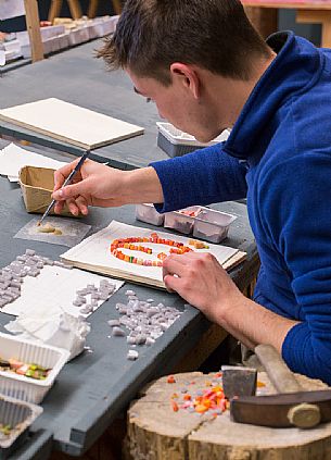 Young boy learns the art of mosaic in the oldest Mosaic School of Friuli , Italy