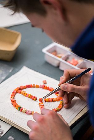 Young boy learns the art of mosaic in the oldest Mosaic School of Friuli, Italy