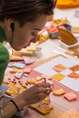 Young girl learns the art of mosaic in the oldest Mosaic School of Friuli , Italy