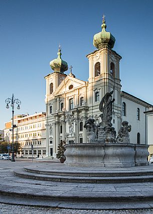 Gorizia's square with Fountain of Nettuno and  the Saint Ignazio church illuminated by early morning light, Friuli, Italy