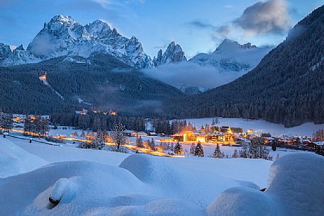 Sesto village and the Sesto Dolomites on background during a winter blue hour, Pusteria valley, Italy