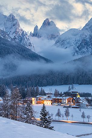 Sesto village and the Sesto Dolomites on background during a winter blue hour, Pusteria valley, Italy
