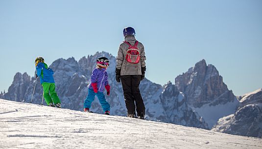 Family of skiers on Mount Elmo, in the background the Croda Dei Toni in the Sesto dolomites natural park, Pusteria valley, Italy