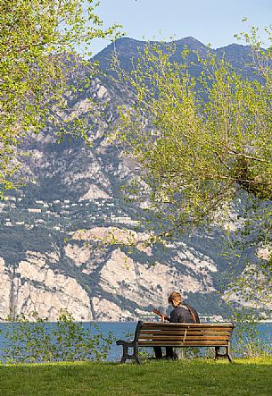 A young musician plays his guitar at Lake Garda near Malcesine, Italy