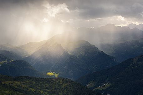 Light rays filter through a cloud in a thunderstorm illuminating the valley in front of the Nuvolau refuge, Dolomites, Cortina D'Ampezzo, Italy