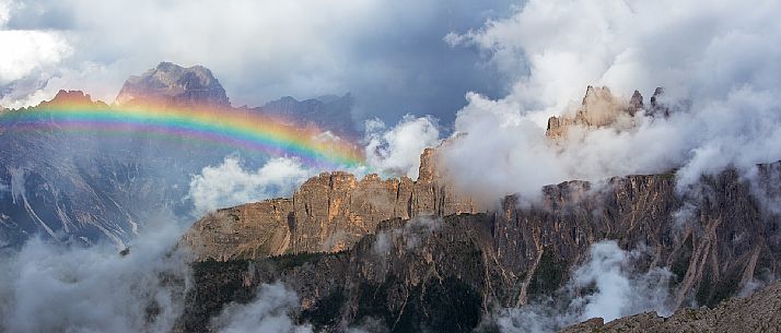 An intense rainbow stands out in front of the Sorapis after a strong thunderstorm with the Croda Da Lago wrapped in the clouds in the foreground, Dolomites, Cortina D'Ampezzo, Italy