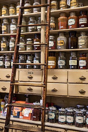 The shelves of the historic Toso grocery store, born in 1906, are high up to the ceiling and on their glass containers all kinds of spices are offered, even the stairs have not changed for more than a century, Trieste, Friuli Venezia Giulia, Italy The shelves of the historic Toso grocery store, born in 1906, are high up to the ceiling and on their glass containers all kinds of spices are offered, even the stairs have not changed for more than a century, Trieste, Friuli Venezia Giulia, Italy