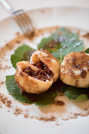 Plums, butter and cinnamon dumplings, typical dish of starred chef Alessandro Gavagna of La Subida Trattoria al Cacciatore in Cormons, Friuli Venezia Giulia, Italy Plums, butter and cinnamon dumplings, typical dish of starred chef Alessandro Gavagna of La Subida Trattoria al Cacciatore in Cormons, Friuli Venezia Giulia, Italy