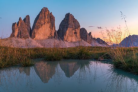 Tre Cime di Lavaredo reflected on a little pond in the Tre Cime Natural Park, Dolomites, South Tyrol, Italy