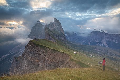 The photographer immortalizes the colors of a cloudy dawn on the Odle group from Seceda, Dolomites, Ortisei, Italy