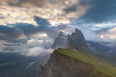 The Odle group wrapped in clouds during a sunrise photographed from Seceda, Dolomites, Ortisei, Italy