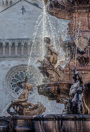 Detail of the Neptune fountain and in the background the Cathedral of San Vigilio in Duomo square, Trento, Trentino Alto Adige, Italy Detail of the Neptune fountain and in the background the Cathedral of San Vigilio in Duomo square, Trento, Trentino Alto Adige, Italy