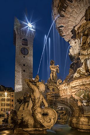 The fountain of Nettuno and the Civic tower in Duomo square at the twilight, Trento, Trentino Alto Adige, Italy