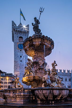 The fountain of Nettuno and the Civic tower in Duomo square at sunset, Trento, Trentino Alto Adige, Italy