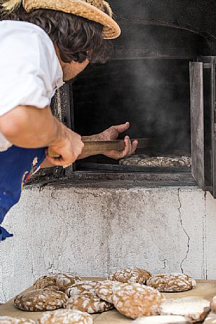 Traditional baking bread during the bread and strudel festival in Duomo square, Bressanone, Isarco valley, Alto Adige, Italy, Europe Traditional baking bread during the bread and strudel festival in Duomo square, Bressanone, Isarco valley, Alto Adige, Italy, Europe