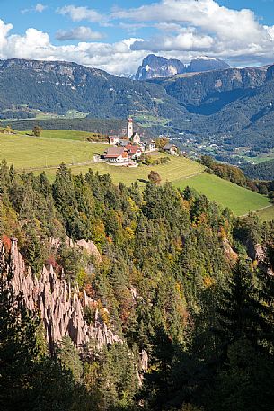 The earth pyramids of the Renon towards Mittelberg and San Nicol church, in the background the Sassolungo dolomitic peak, Altopiano del Renon, Trentino Alto Adige, Italy, Europe