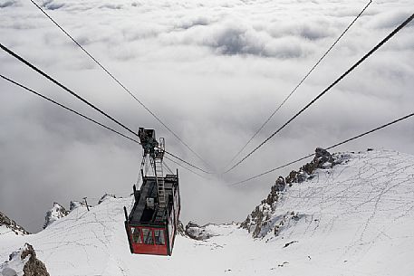 The cableway to the Lagazuoi mount adn refuge emerges from the sea of clouds, Cortina d'Ampezzo, dolomites, Veneto, Italy, Europe