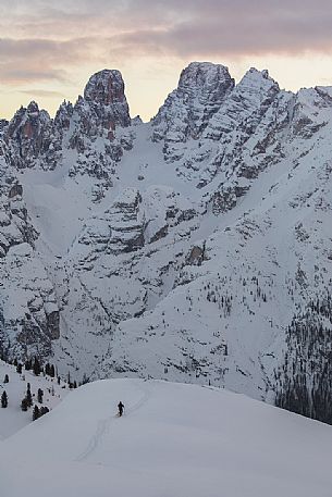 Trekker with snowshoes at sunset, on background the Piz Popena and Cristallo Mount,  Prato Piazza, Braies, Trentino Alto Adige, Italy
