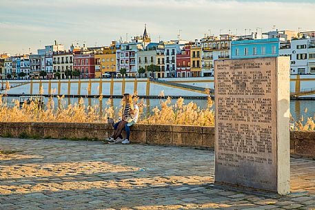 Pair at sunset, in the background the district of Triana, on the western bank of the Guadalquivir river, Seville, Andalusia,  Spain, Europe