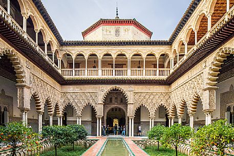 Patio de las Doncellas in the Real Alcazar palace, the lower part with plaster arches and stuccoes is in Mudejar style while the upper loggia shows the influence of the Italian Renaissance, Seville, Andalusia, Spain, Europe Patio de las Doncellas in the Real Alcazar palace, the lower part with plaster arches and stuccoes is in Mudejar style while the upper loggia shows the influence of the Italian Renaissance, Seville, Andalusia, Spain, Europe