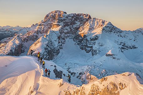 Hikers on the mountain ridge of the path that leading to the Vallandro Peak, on background the Croda Rossa over Prato Piazza Valley in the Fanes Senes Braies Natural Park, Pustertal, dolomites, South Tyrol, Italy, Europe