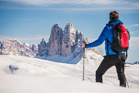 Hiker admires the Tre Cime di Lavaredo peak from Prato Piazza, Fanes Senes Braies Natural Park, Pustertal, dolomites, South Tyrol, Italy, Europe Hiker admires the Tre Cime di Lavaredo peak from Prato Piazza, Fanes Senes Braies Natural Park, Pustertal, dolomites, South Tyrol, Italy, Europe