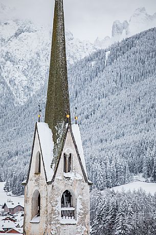 The snow covered bell tower of the church of Villabassa, Trentino Alto Adige, dolomites, Pusteria valley, Italy, Europe
