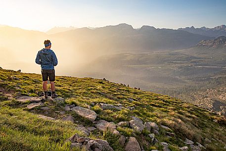 Trekker admires the panoramic view over the Rolle Pass, San Martino di Castrozza, dolomites, Trentino Alto Adige, Italy, Europe