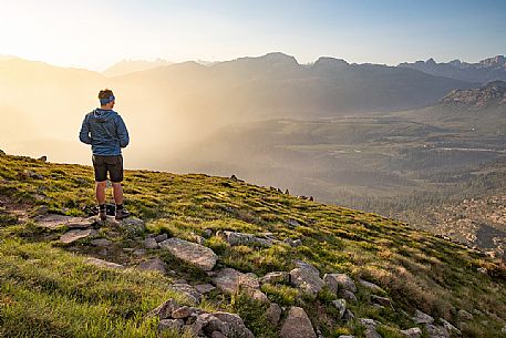 Trekker admires the panoramic view over the Rolle Pass, San Martino di Castrozza, dolomites, Trentino Alto Adige, Italy, Europe Trekker admires the panoramic view over the Rolle Pass, San Martino di Castrozza, dolomites, Trentino Alto Adige, Italy, Europe