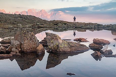 Hiker at the Juribrutto lakes with Pale di San Martino mountain group at sunset, San Martino di Castrozza, dolomites, Trentino Alto Adige, Italy, Europe Hiker at the Juribrutto lakes with Pale di San Martino mountain group at sunset, San Martino di Castrozza, dolomites, Trentino Alto Adige, Italy, Europe