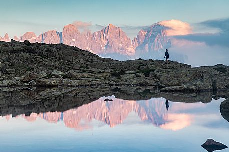 Hiker at the Juribrutto lakes with Pale di San Martino mountain group at sunset, San Martino di Castrozza, dolomites, Trentino Alto Adige, Italy, Europe Hiker at the Juribrutto lakes with Pale di San Martino mountain group at sunset, San Martino di Castrozza, dolomites, Trentino Alto Adige, Italy, Europe