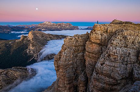 Hiker looks the moon rising and the clouds wrap around the landscape nearby Lagazuoi Refuge, Cortina d'Ampezzo, Veneto, Italy, Europe Hiker looks the moon rising and the clouds wrap around the landscape nearby Lagazuoi Refuge, Cortina d'Ampezzo, Veneto, Italy, Europe