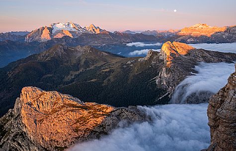 Clouds wrap around the landscape nearby Lagazuoi refuge at dawn, in the background the Marmolada mount, Cortina d'Ampezzo, Veneto, Italy, Europe