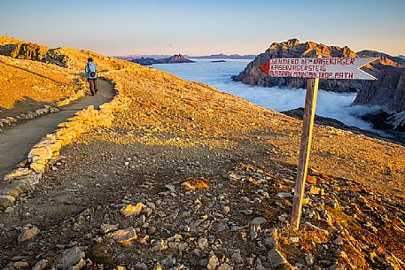 Trekker and the sign of Keiserjager's path nearby Lagazuoi refuge, Cortina d'Ampezzo, dolomites, Veneto, Italy, Europe