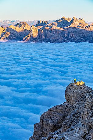 Photographer looks the sunrise towards the Odle mountain group and the clouds wrap around the landscape nearby Lagazuoi Refuge, Cortina d'Ampezzo, Veneto, Italy, Europe