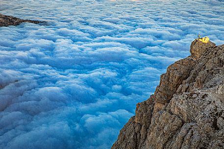 Photographer sourranded by a low clouds sea on the top of Lagazuoi mount, Cortina d'Ampezzo, dolomites, Veneto, Italy, Europe Photographer sourranded by a low clouds sea on the top of Lagazuoi mount, Cortina d'Ampezzo, dolomites, Veneto, Italy, Europe
