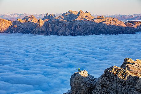 Photographer looks the sunrise towards the Odle Puez natural park and the clouds wrap around the landscape nearby Lagazuoi Refuge, Cortina d'Ampezzo, Veneto, Italy, Europe Photographer looks the sunrise towards the Odle Puez natural park and the clouds wrap around the landscape nearby Lagazuoi Refuge, Cortina d'Ampezzo, Veneto, Italy, Europe
