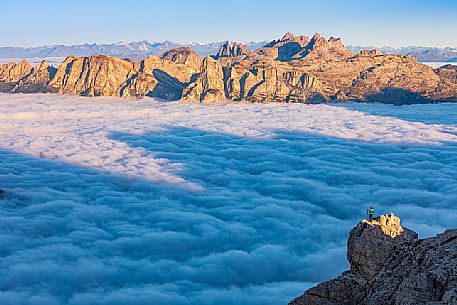 Photographer looks the sunrise towards the Odle Puez natural park and the clouds wrap around the landscape nearby Lagazuoi Refuge, Cortina d'Ampezzo, Veneto, Italy, Europe