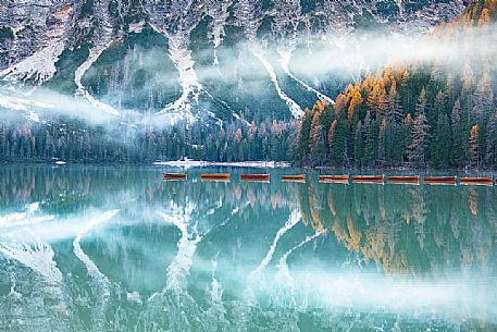 Row of boats moored in the lake of Braies in autumn, dolomites, Pusteria valley, Trentino Alto Adige, South Tyrol, Italy, Europe