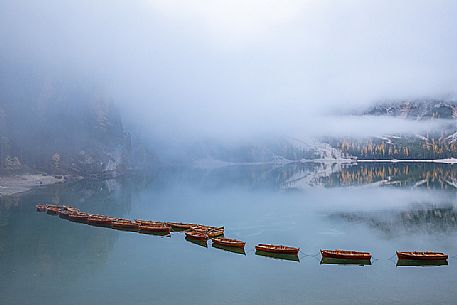 Row of boats moored in the lake of Braies in autumn, dolomites, Pusteria valley, Trentino Alto Adige, South Tyrol, Italy, Europe
