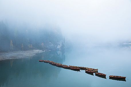 Row of boats moored in the lake of Braies in autumn, dolomites, Pusteria valley, Trentino Alto Adige, South Tyrol, Italy, Europe