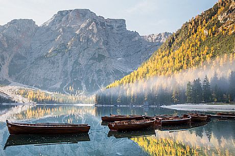 Row of boats moored in the lake of Braies in autumn, dolomites, Pusteria valley, Trentino Alto Adige, South Tyrol, Italy, Europe