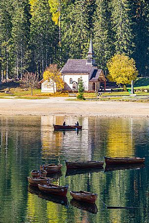 The Little church of Braies lake with autumn colors, dolomites, Pusteria valley, Trentino Alto Adige, Italy, Europe