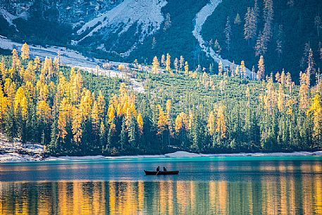 Pair of tourists in a boat on Lake Braies with autumn colors, dolomites, Pusteria valley, Trentino Alto Adige, South Tyrol, Italy, Europe Pair of tourists in a boat on Lake Braies with autumn colors, dolomites, Pusteria valley, Trentino Alto Adige, South Tyrol, Italy, Europe