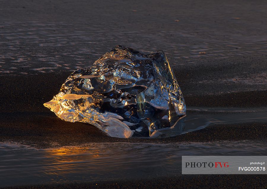 A fragment of ice stranded on the volcanic beach of Jokulsarlon clearly shows the strong contrast of the icelandic nature