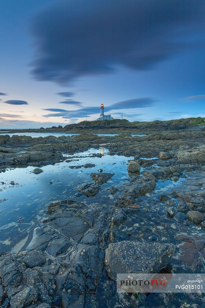 The view of the lighthouse from the rocks during a windy day. This picture has been taken few minutes after the sunset