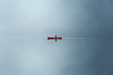 Rowing boat on the lake in the morning fog