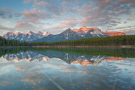 Moon is reflected at Herbert Lake during a colorful sunrise