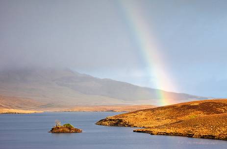 While Old Man of Storr is hiding behind the clouds a beautiful rainbow shows up in the landscape