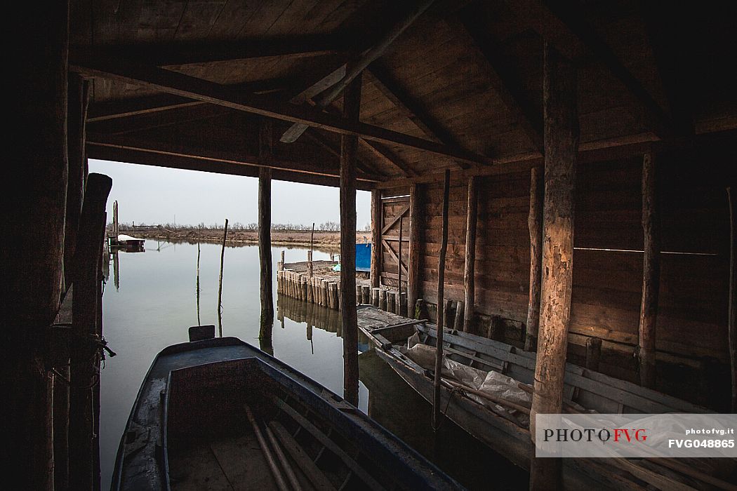 Boats inside a fisherman's pier in the venetian lagoon in Lio Piccolo village, Veneto, Italy, Europe